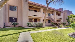 A multi-story building with a flat roof, balconies, and a central staircase. - Pool Side - Unit 114 (Mesa)