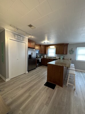 Enjoy cooking in this well-equipped kitchen with a central island, stainless steel appliances, and ample counter space.