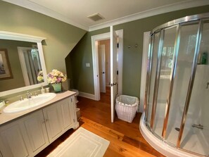 Baño con ducha, lavamanos y espejo.