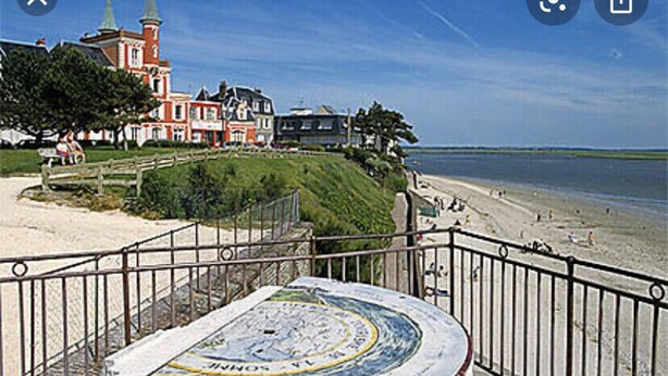 Eine Küstenansicht mit einer Kirche, Strand und einer Straßenbahn.