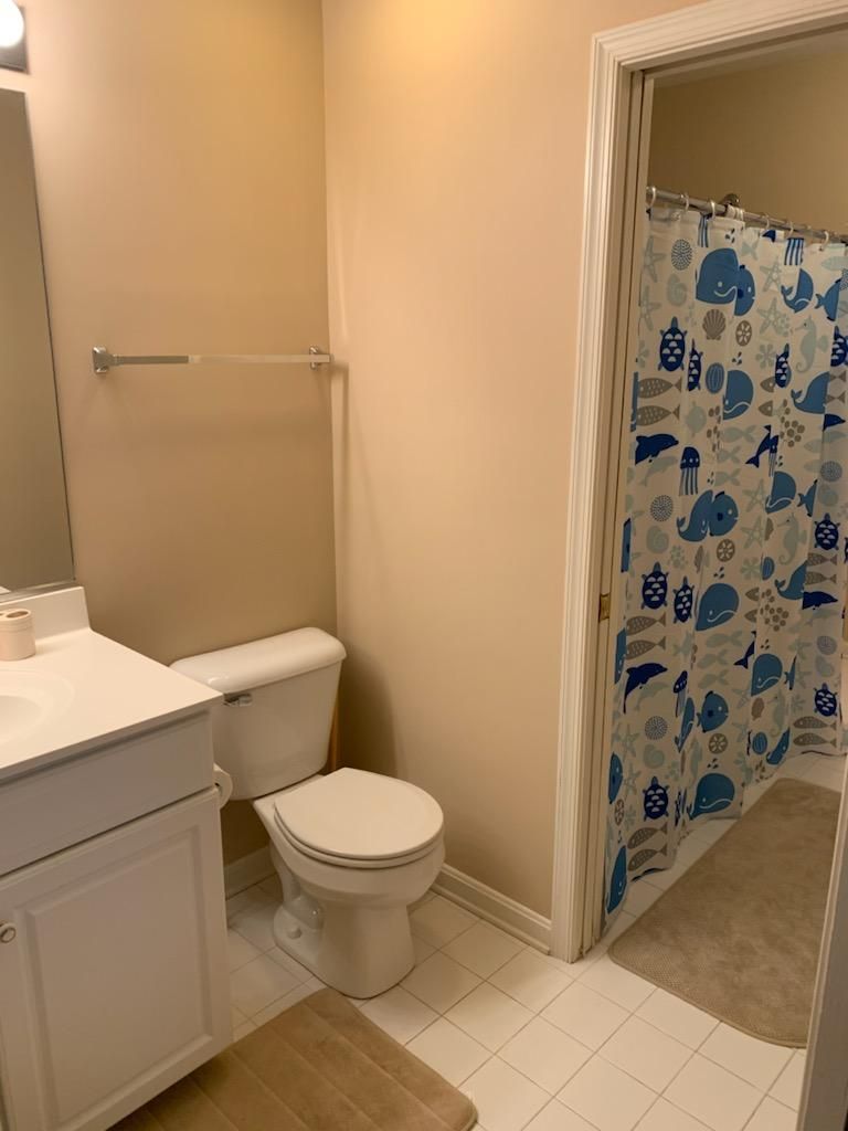 A bathroom with a toilet, a sink, and a mirror.