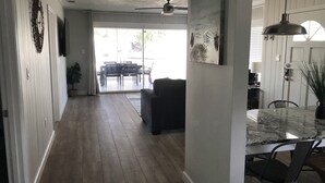 A spacious kitchen with a dining area, a ceiling fan, and a large window.