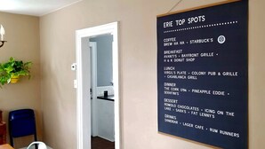 A room with a wall-mounted menu listing various food and drink options at ERIE TOP SPOTS.