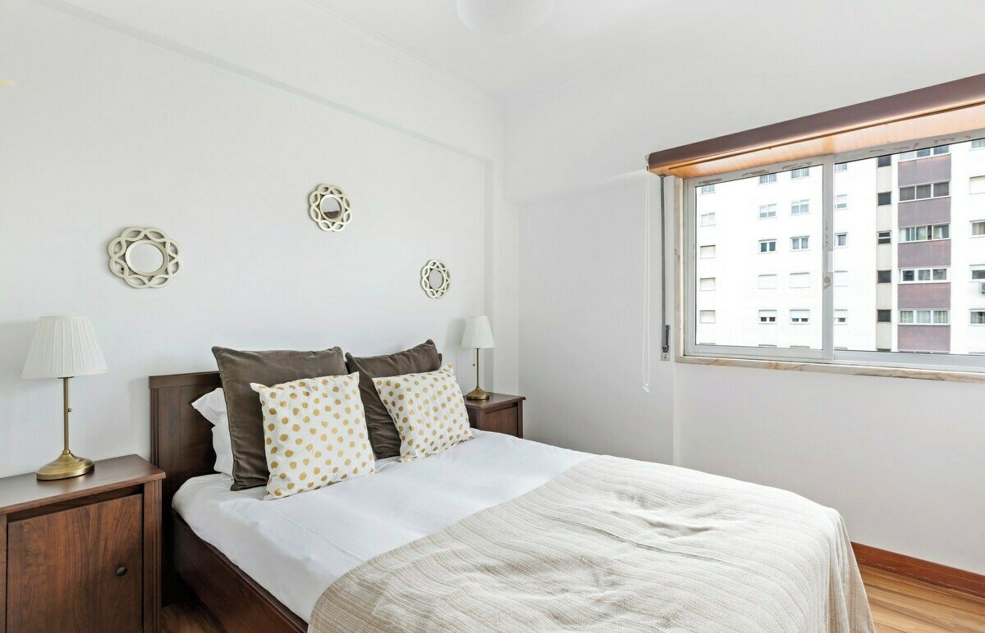 Une chambre à coucher comprenant un lit, deux tables de chevet, une fenêtre et des éléments décoratifs sur les murs.