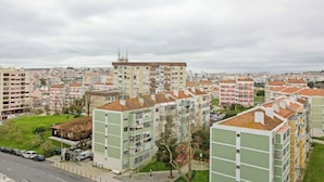 A residential area with multi-story buildings, a road, and a grassy area with trees. - Bright & Spacious Three-Bed Apartment in Lisbon (Lisboa)