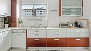 A modern kitchen with a built-in oven, a sink, and a window with a view of buildings. - Bright & Spacious Three-Bed Apartment in Lisbon (Lisboa)