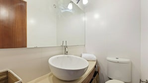 A bathroom with a large white sink, a mirror, a toilet, and a wooden cabinet. - Bright & Spacious Three-Bed Apartment in Lisbon (Lisboa)