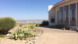 A desert landscape with a building featuring large windows and a red-tiled roof. - PERFECT DESERT OASIS~lake~jet ski~boat (Truth or Consequences)