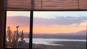 A window with a view of a desert landscape at sunset, including cacti and distant mountains. - PERFECT DESERT OASIS~lake~jet ski~boat (Truth or Consequences)