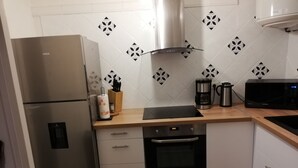 A modern kitchen with a stainless steel refrigerator, a built-in oven, a microwave, and a coffee maker on the countertop. - Magnifique T3 vue MER, Port de St Cyprien plage (Saint-Cyprien)