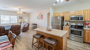 A modern kitchen with wooden cabinets, stainless steel appliances, and a central island with stools. - Great Value, near golf,hiking: Superstition Escape (Gold Canyon)