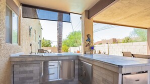 A modern kitchen with a built-in dishwasher, a large window, and a view of the backyard. - Great Value, near golf,hiking: Superstition Escape (Gold Canyon)