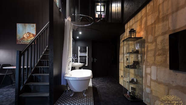 Un baño moderno con una bañera independiente, un cerramiento de ducha de vidrio y un armario para zapatos.