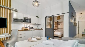 Une chambre d’hôtel moderne équipée d’un lit, d’une table de chevet et d’une kitchenette.