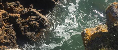 Une côte rocheuse où les vagues s'écrasent contre les rochers.
