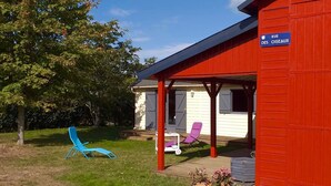 A red building with a covered porch and a sign reading "RUE DES OISEAUX". - Welcome to Rue des oiseaux (Névez)