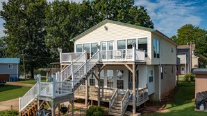 A two-story house with a front deck, a staircase, and a small porch. - Lakefront, two bedroom, full bath. Relax, swim, kayak & fish on Lake Lookout. (Claremont)