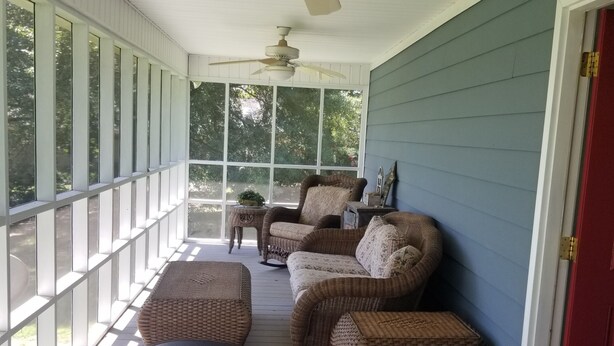 A covered porch with wicker furniture, ceiling fans, and large windows. - Charming House near Gardner Webb (Cliffside)