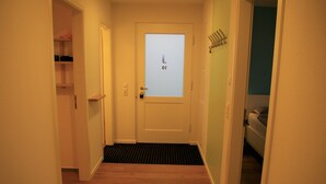 A hallway with a door featuring a frosted glass window displaying the text "of."