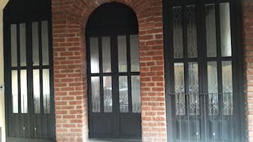 A building facade with three large windows, each with a black frame and decorative glass patterns.