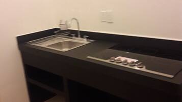 Una cocina compacta con fregadero, estufa y encimera.