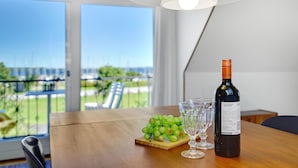 A table with a bottle of wine, a glass, and a bunch of grapes. - Cozy home in Stubbekøbing with kitchen (Stubbekøbing)
