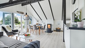 Un intérieur moderne comprenant un coin repas, une cuisine et un espace salon.