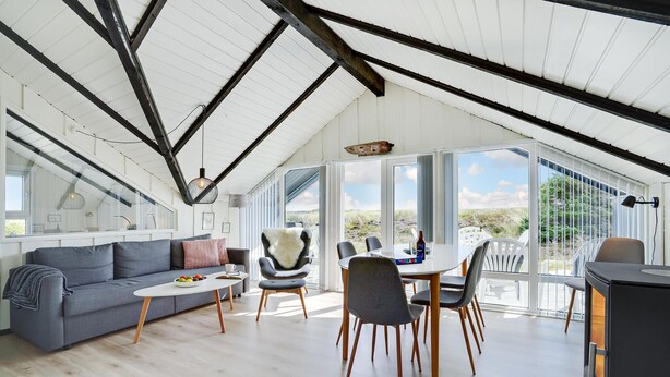 Un loft spacieux avec de hauts plafonds, de grandes fenêtres, un coin repas et un espace salon confortable.