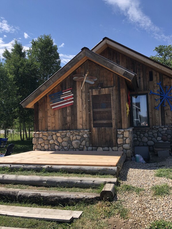 Experience a classic country getaway with a traditional cabin featuring a welcoming porch and patriotic charm.