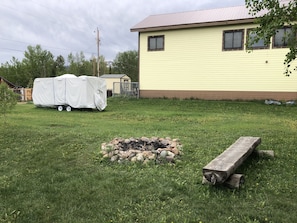 Enjoy a peaceful retreat in this serene single-story home with a lawn and fire pit area.