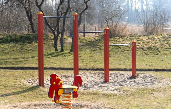 A playground with a red and yellow seesaw and a metal climbing structure. - Gorgeous home in Zierow with sauna (Zierow)