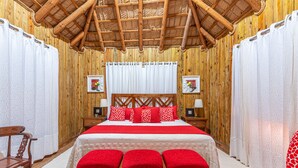 A wooden room with a bed, wooden walls, and a thatched roof. - Hotel Vista de Aguilas Ecolodge (Pedernales)