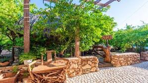 A rustic outdoor area with a stone pathway, wooden furniture, and a pergola structure. - Hotel Vista de Aguilas Ecolodge (Pedernales)