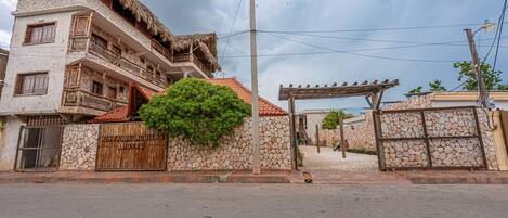 Un hotel con fachada de piedra, tejado de paja y una puerta de madera.