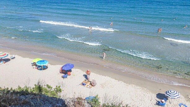 A beach with clear blue water, people swimming and sunbathing, and several beach umbrellas. - 2 bedroom lovely apartment in Orihuela costa (Orihuela costa)