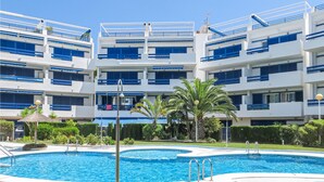A hotel with multiple balconies, a swimming pool, and lush greenery. - 2 bedroom lovely apartment in Orihuela costa (Orihuela costa)