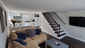 Ein modernes Wohnzimmer mit Sofa, Couchtisch und Treppe.