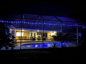 A covered outdoor area with a pool, string lights, and a seating area. - Family Friendly heated pool Home 2000sqft <br>“NO parties” (Palm Harbor)