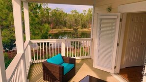 A covered porch with wicker furniture and a view of a lake and trees. - FREE Street Legal Golf Cart, 6 blocks to beach 3 blocks from incredible pool! (Santa Rosa Beach)