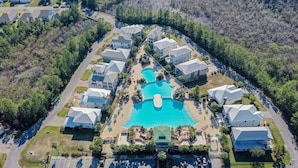 An aerial view of a resort with a central swimming pool, surrounded by uniformly designed villas, and a parking area in the foreground. - FREE Street Legal Golf Cart, 6 blocks to beach 3 blocks from incredible pool! (Santa Rosa Beach)