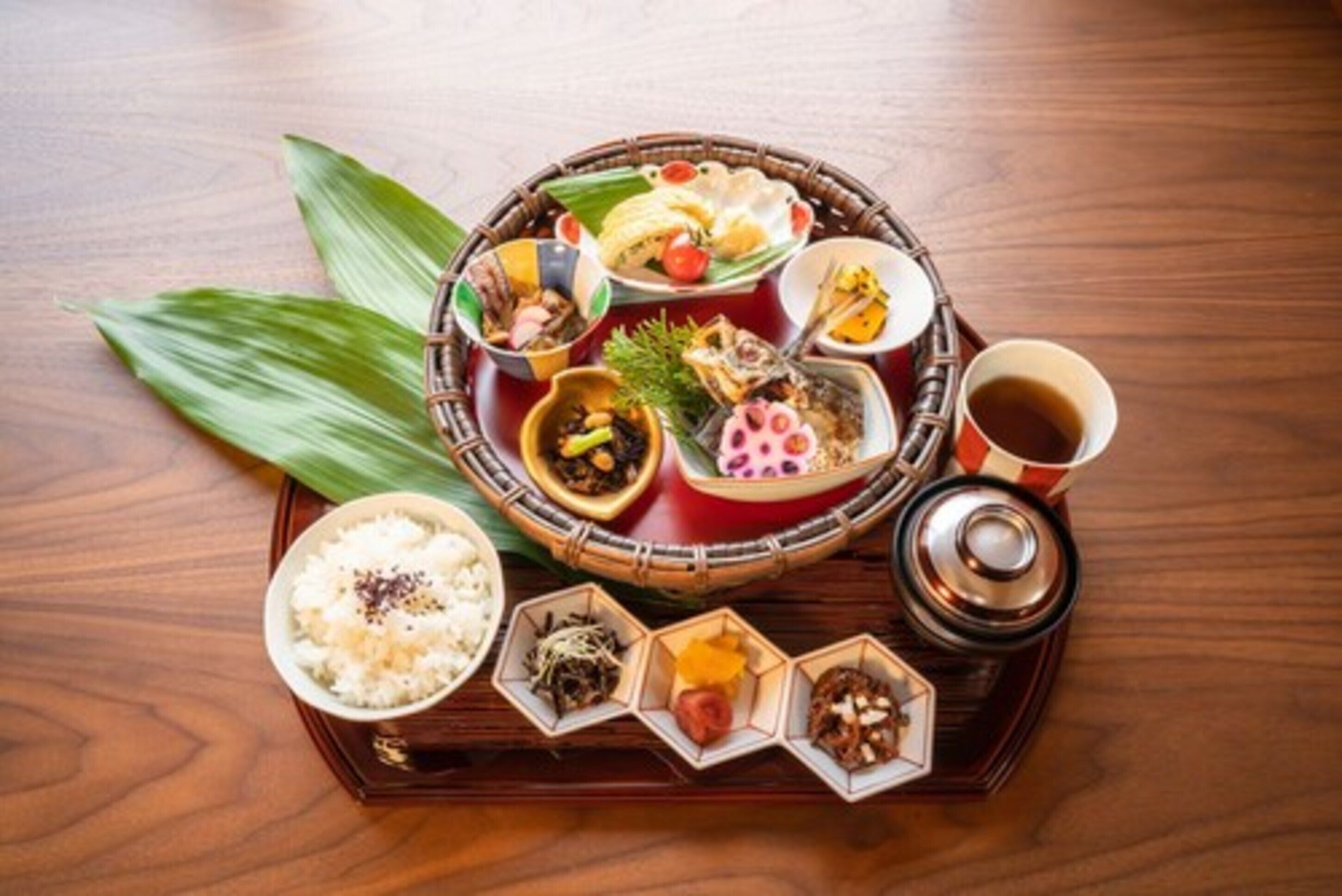 A traditional Japanese meal setup with various dishes and a tea set on a wooden table.