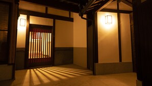 Un interior japonés tradicional con suelo de tatami, vigas de madera y puertas correderas.
