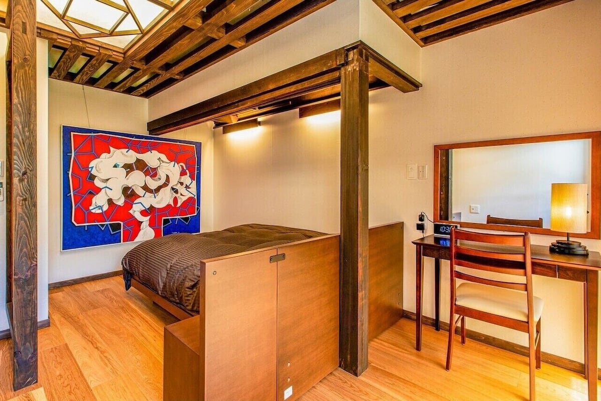 Habitación pequeña con cama, escritorio y silla.