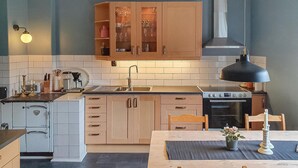 Una cocina compacta con una isla central, estufa y lavamanos.