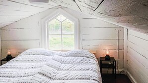 Un dormitorio con una cama grande, una ventana y dos lámparas de noche.