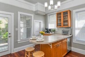 A kitchen with a central island, wooden cabinets, a built-in oven, and a chandelier.