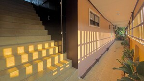 A staircase with a handrail, a tiled floor, and a wall with a window and a door. - Baan Baramee House (Chiang Rai)