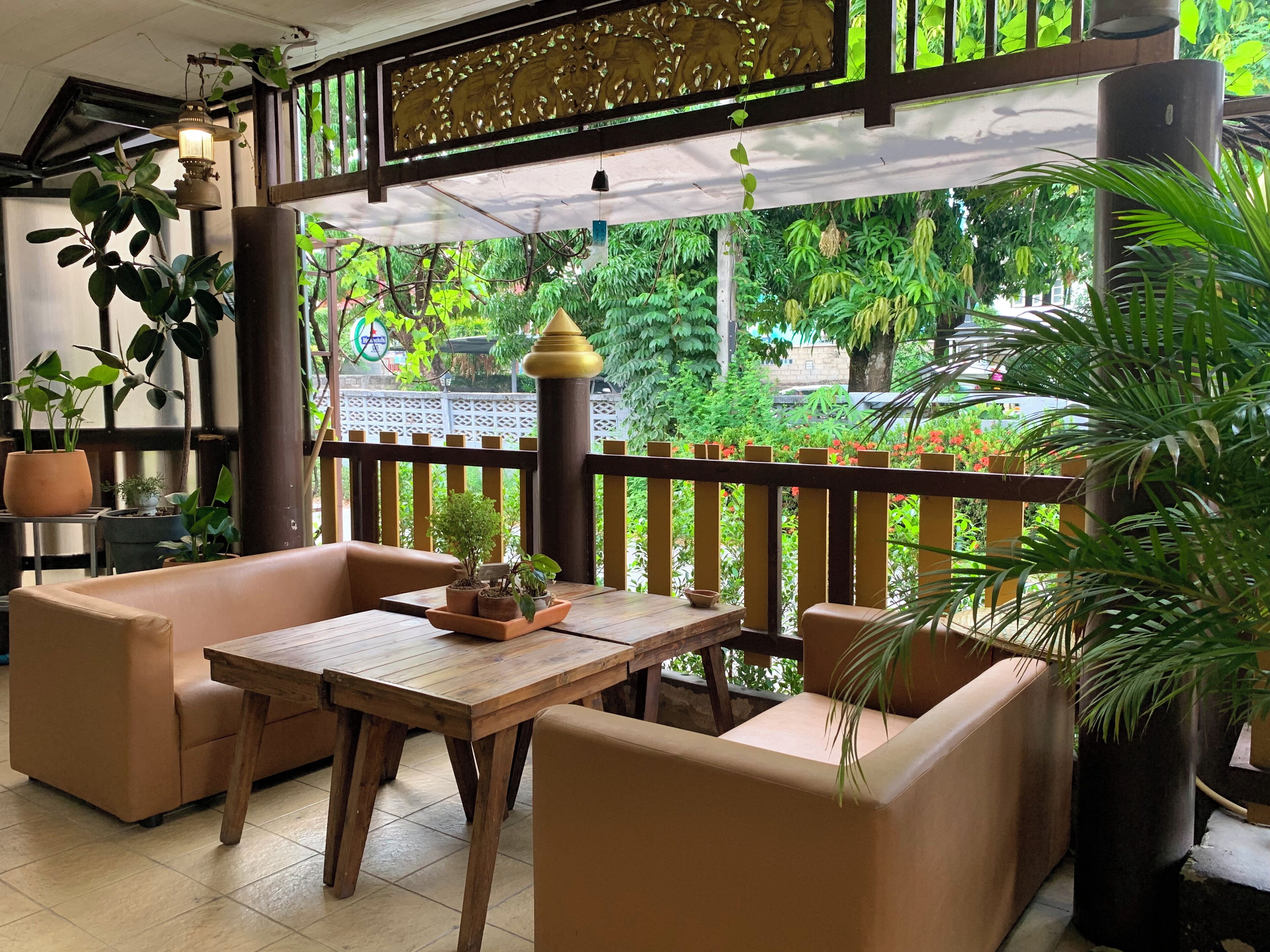 Un espace extérieur accueillant, aménagé avec du mobilier en bois et des plantes en pot.