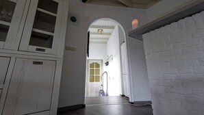 A hallway with white wooden cabinets, a white brick wall, and a door leading to another room. - Room-room to Rent With own Entrance, liv (Blitterswijck)
