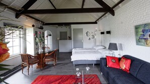 A modern room with a bed, a sofa, a dining table with chairs, and a kitchen area. - Room-room to Rent With own Entrance, liv (Blitterswijck)